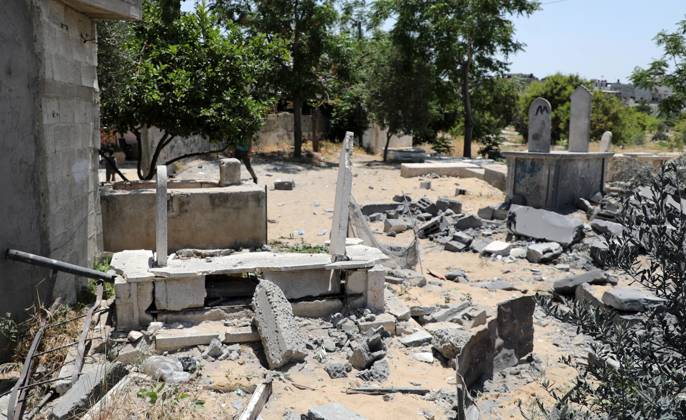 Palestinians inspect the rubble of a cemetery following an Israeli air ...