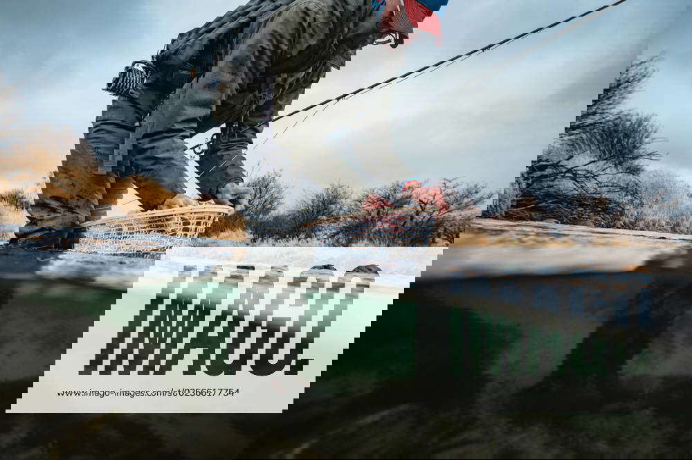 Underwater photo of fly fisherman unhooking fish in net Emigrant