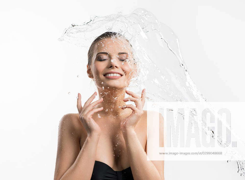 Pretty girl enjoying water splash studio shot Young beautiful girl her ...