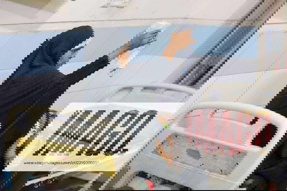 July 14, 2023, Dhaka, Bangladesh A mother holds IV fluids as her child