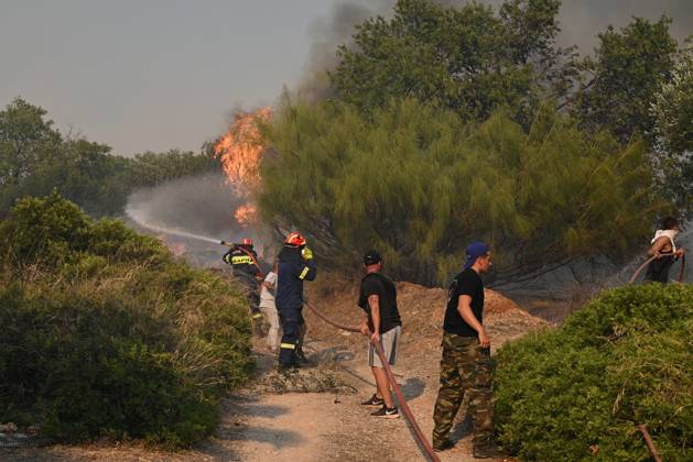 Wildfire Rages In Saronida Near Athens A firefighter operates as a ...