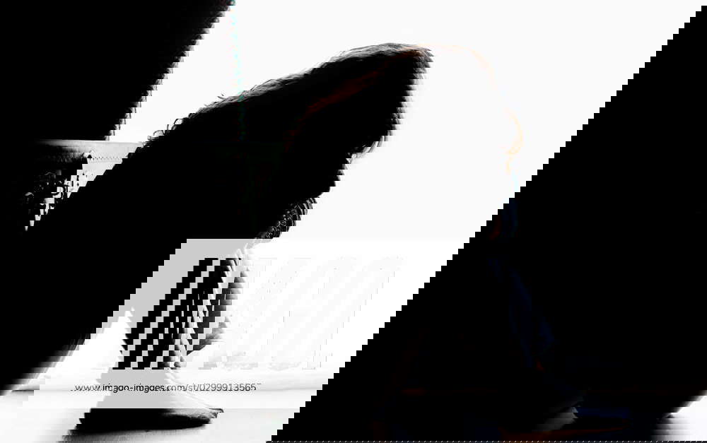 Unhappy mature lady, woman in silhouette, sitting on the floor with