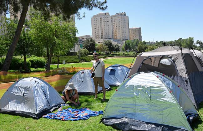 Israelis secure their tent in an encampment set up by anti-government ...