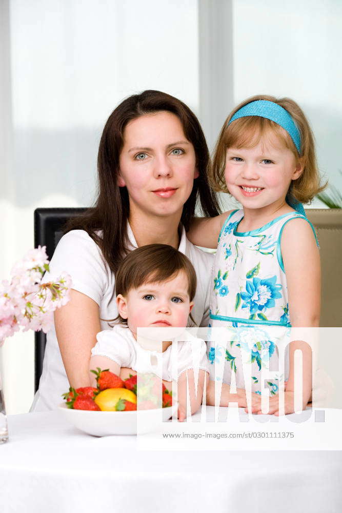 Mom And Daughters A Young Woman And Two Daughter In The Living Room