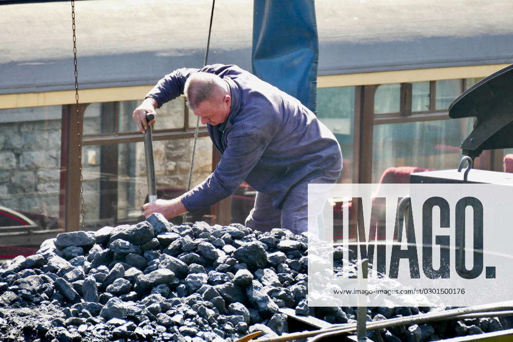 Seasonal weather Steam train drivers shovel coal in the heat whilst ...