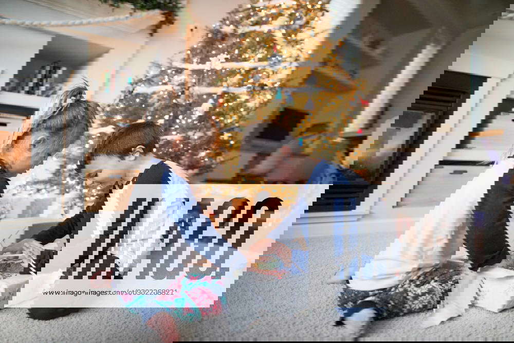 Brother and sister work together to unwrap christmas gifts Langley, British Columbia, Canada