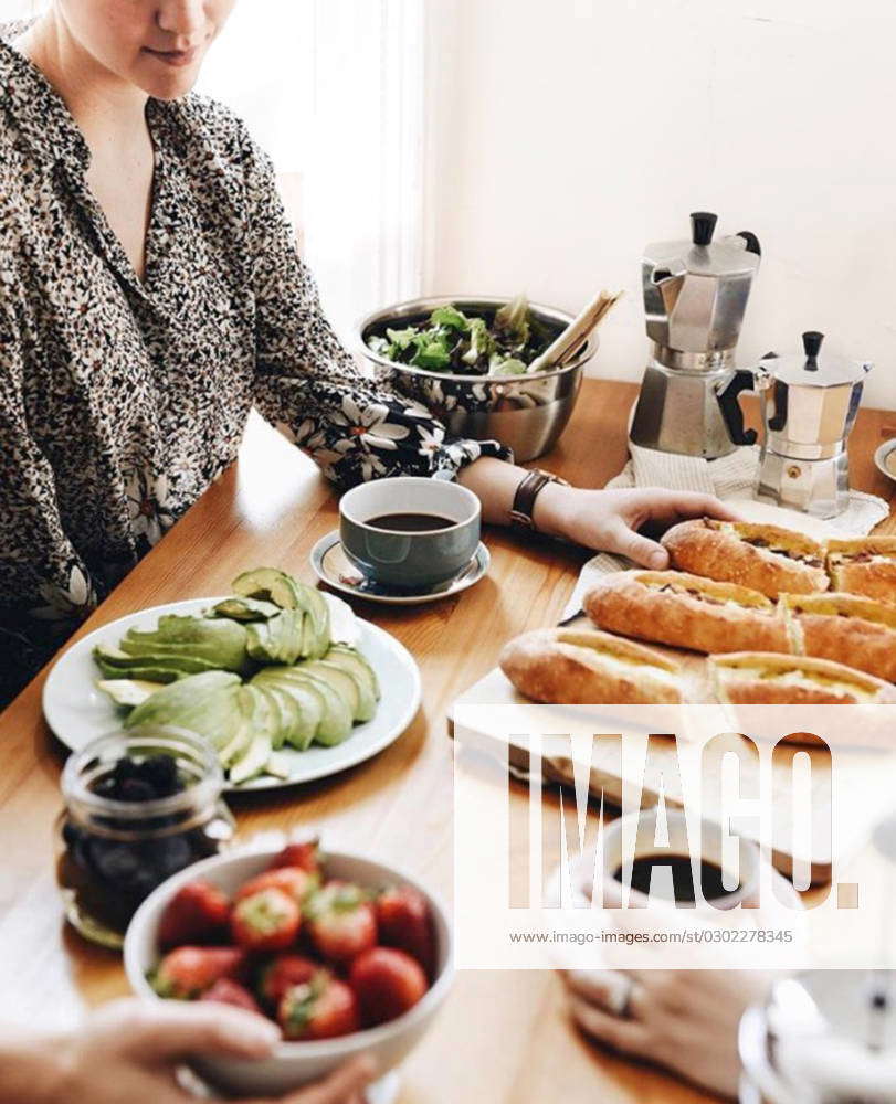 Young women gather around a bright brunch spread at home New York, New