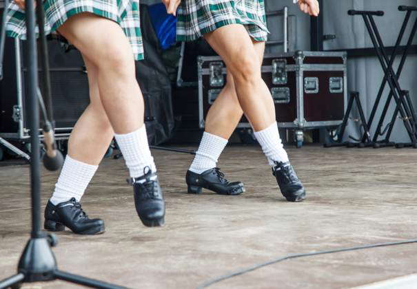 Female legs of two irish dancers in green checkered dresses on the ...