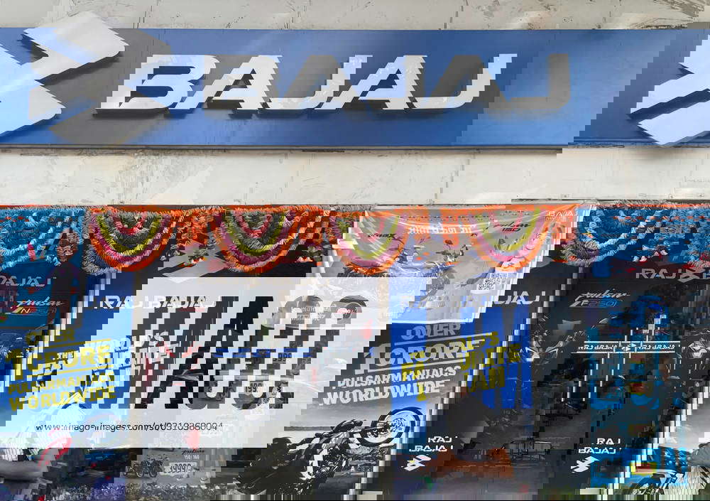 Business And Finance In Mumbai A man walks past a Bajaj motorcycle