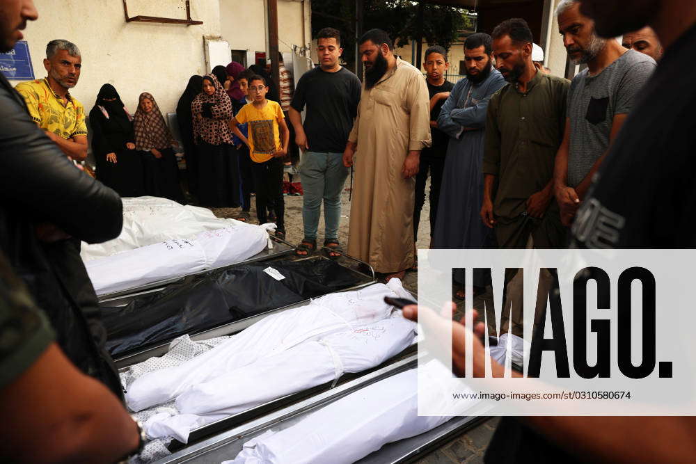 Palestinian Relatives Wait To Collect The Bodies Of Victims At The Al