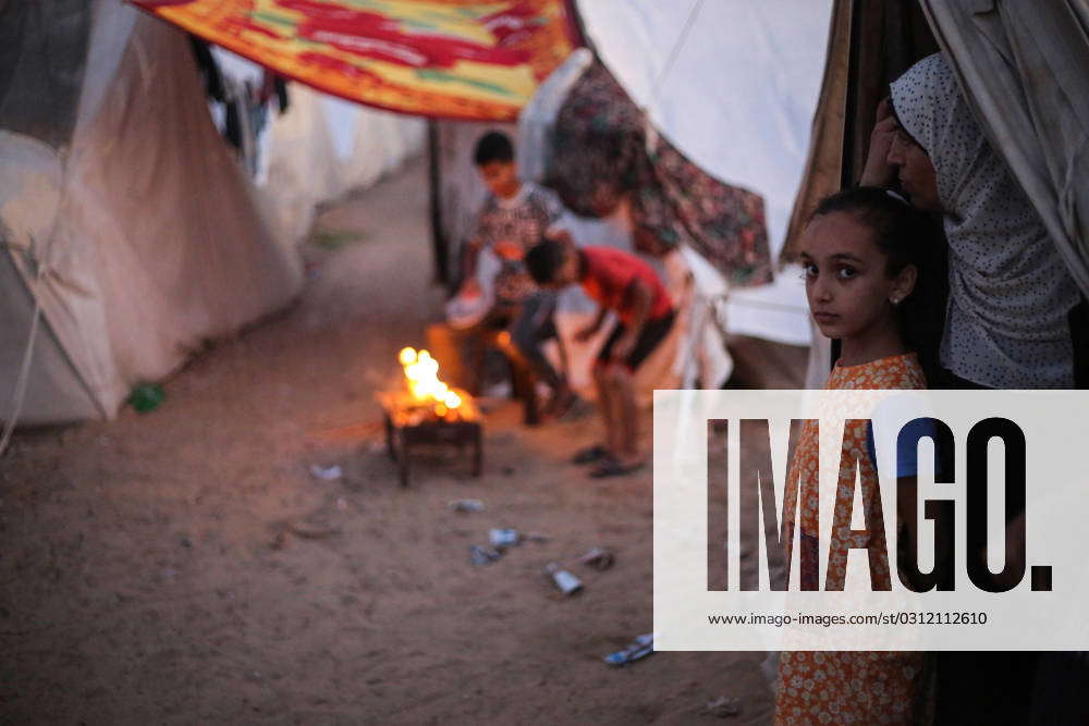 : A Displaced Palestinian girl stands in front of her family tent at a ...