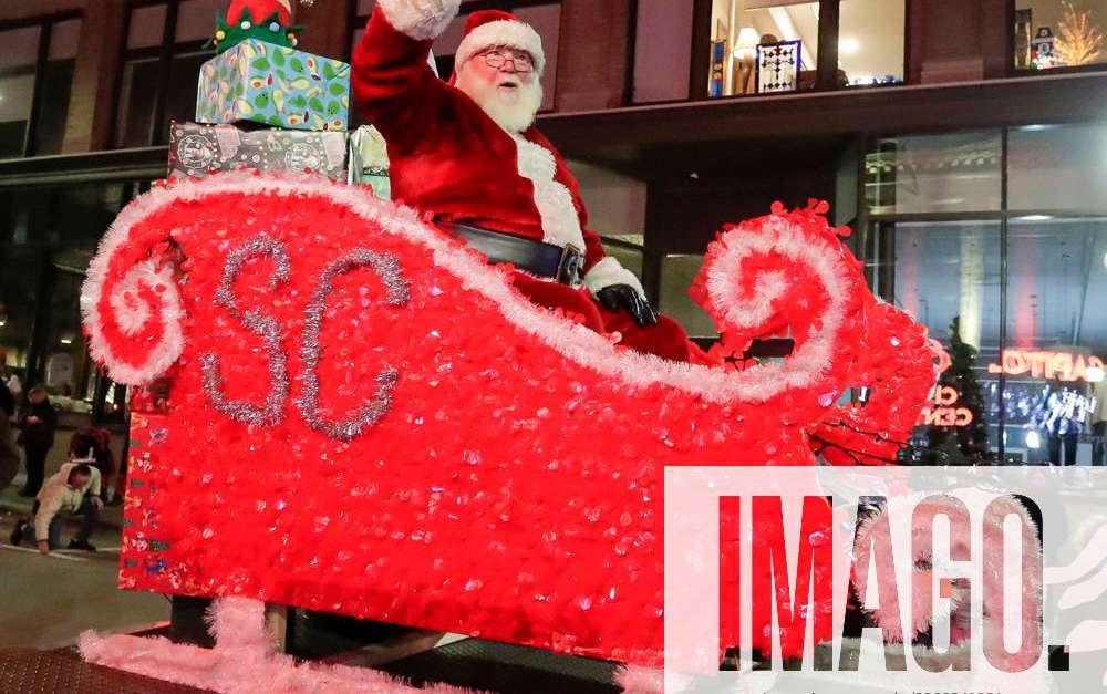 Syndication: Sheboygan Press Santa waves from his sled during the ...