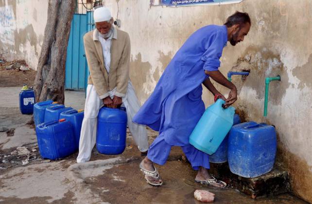 HYDERABAD, PAKISTAN, DEC 16: People are filling their water cans from ...