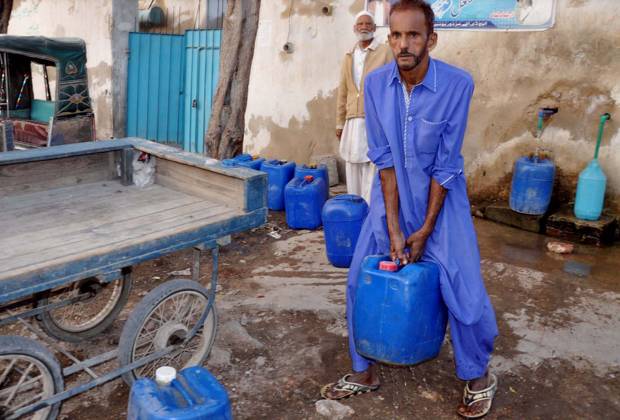 HYDERABAD, PAKISTAN, DEC 16: People are filling their water cans from ...