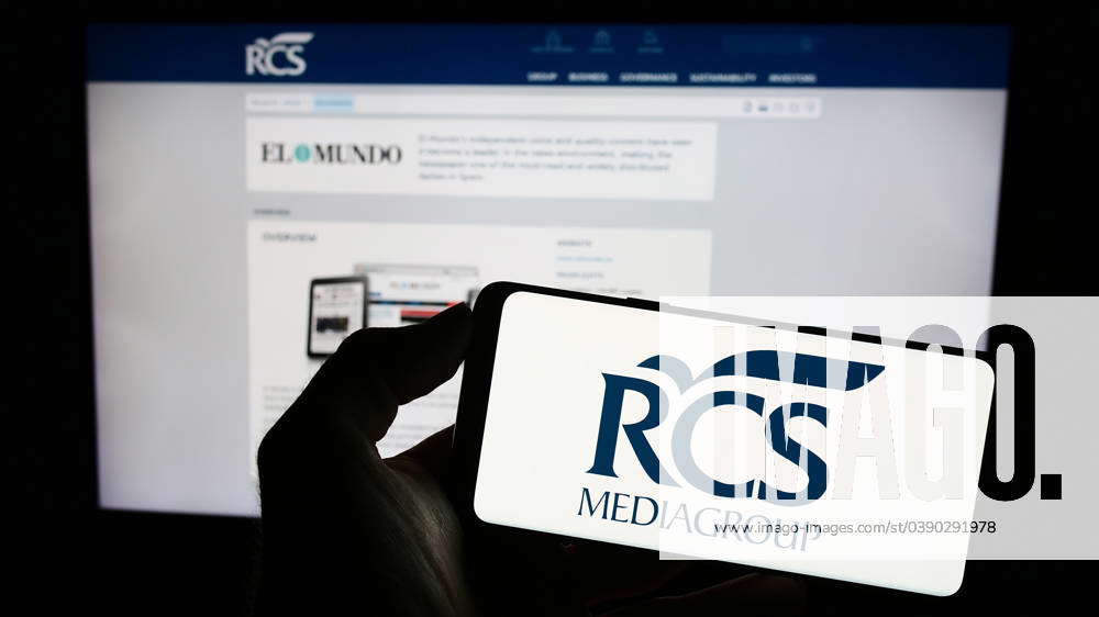 Person holding cellphone with logo of Italian media company RCS ...