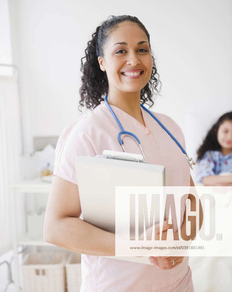 Smiling mixed race nurse in hospital room Jersey City, New Jersey, USA