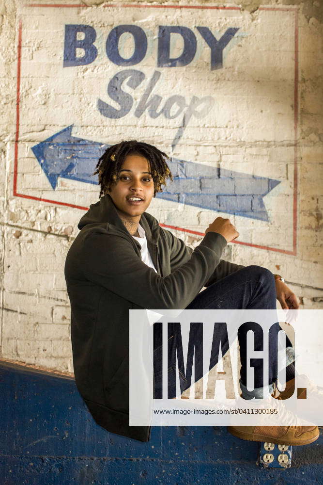 Portrait of androgynous Mixed Race woman sitting in body shop Oakland