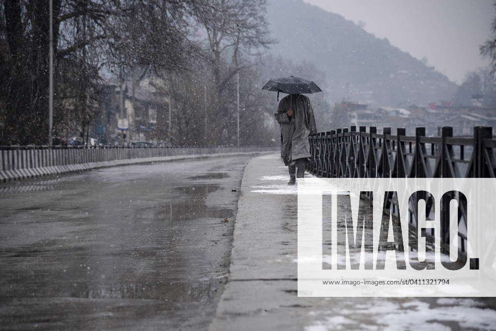 Snowfall in Srinagar, India 03 Jan 2024 A man holding an umbrella