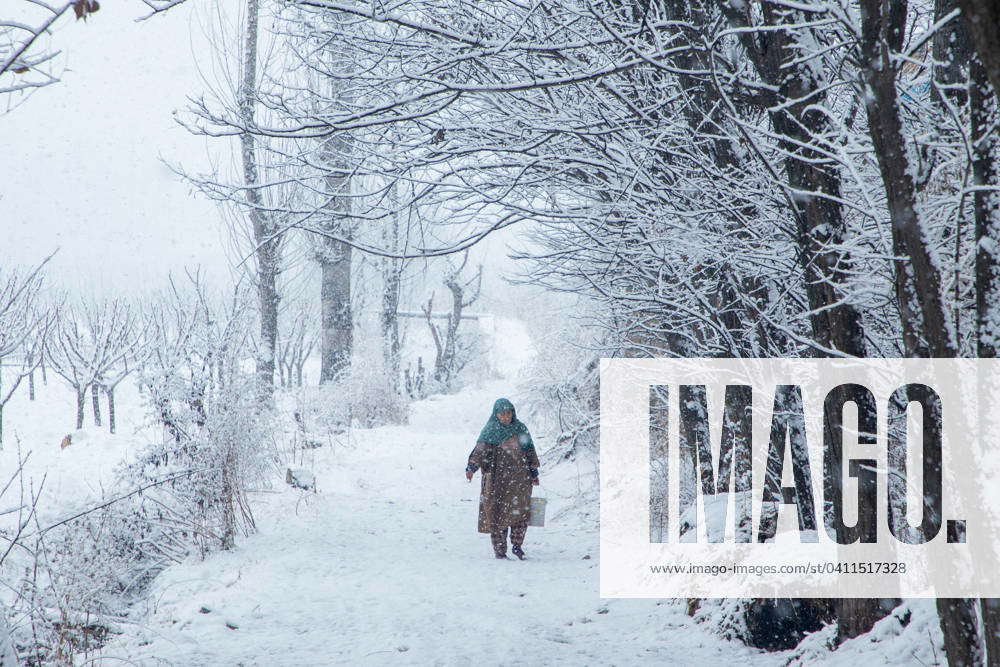 Snowfall in Srinagar, India 04 Jan 2024 A Kashmiri woman walks along a snowcovered street amid