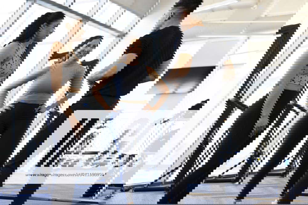 Fitness trainer pointing to abs explaining benefits of a workout while