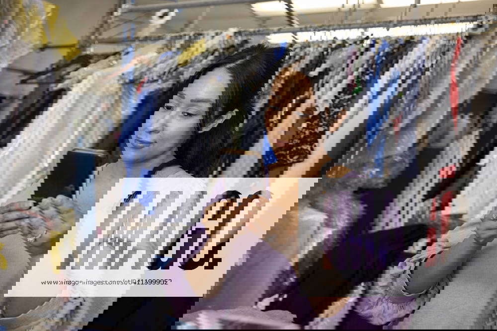 Woman using phone while working at dry cleaners Dallas Texas United States