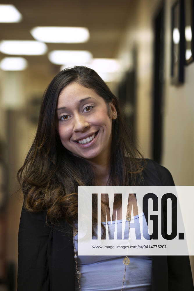 Portrait of young woman smiling in hallway of office building Dallas ...