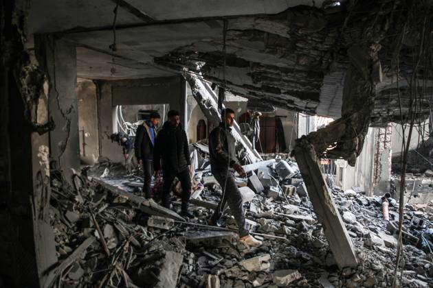 Palestinian artist Mahmoud Zuaiter inspects the ruins of his house ...