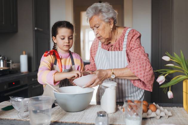 Grandmother with grandaughter preparing traditional easter meals ...