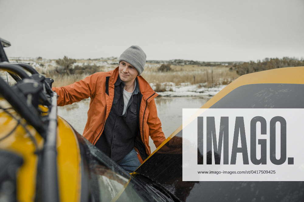 A Caucasian young male holds onto his SUV stranded in a puddle. Menan ...