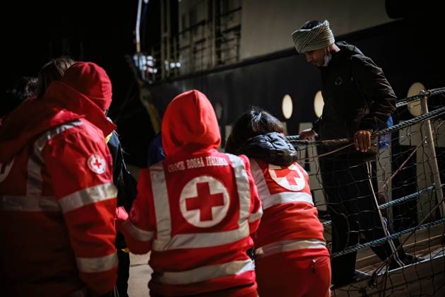 Crotone, Italy: Members of the Red Cross seen with a migrant. The ...