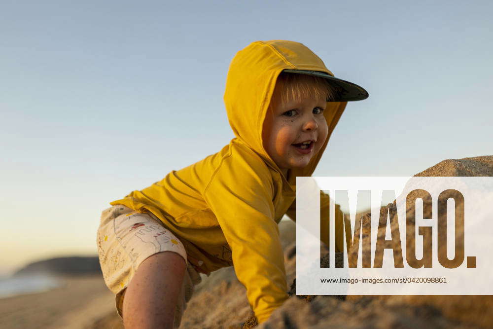 A young boy plays on the sand in Mexico at sunset. El Pescadero, Baja ...