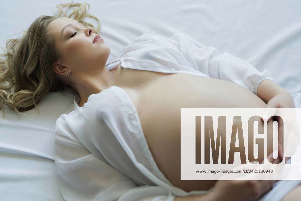 Barely Legal Pregnant Nude - Young pregnant nude girl in bed cropped portrait Young pregnant girl with  blonde locks lying in