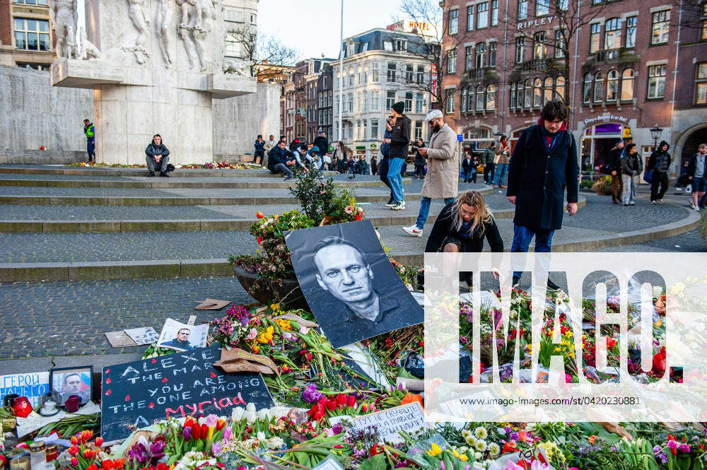 Flowers in memory of Navalny in Amsterdam. A couple is seen fixing the ...