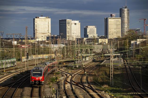 Train on the tracks west of the main station of Essen, skyline of the ...