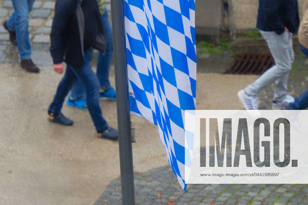 Feet and flag Pedestrians walk past the Bavarian diamond flag Munich ...