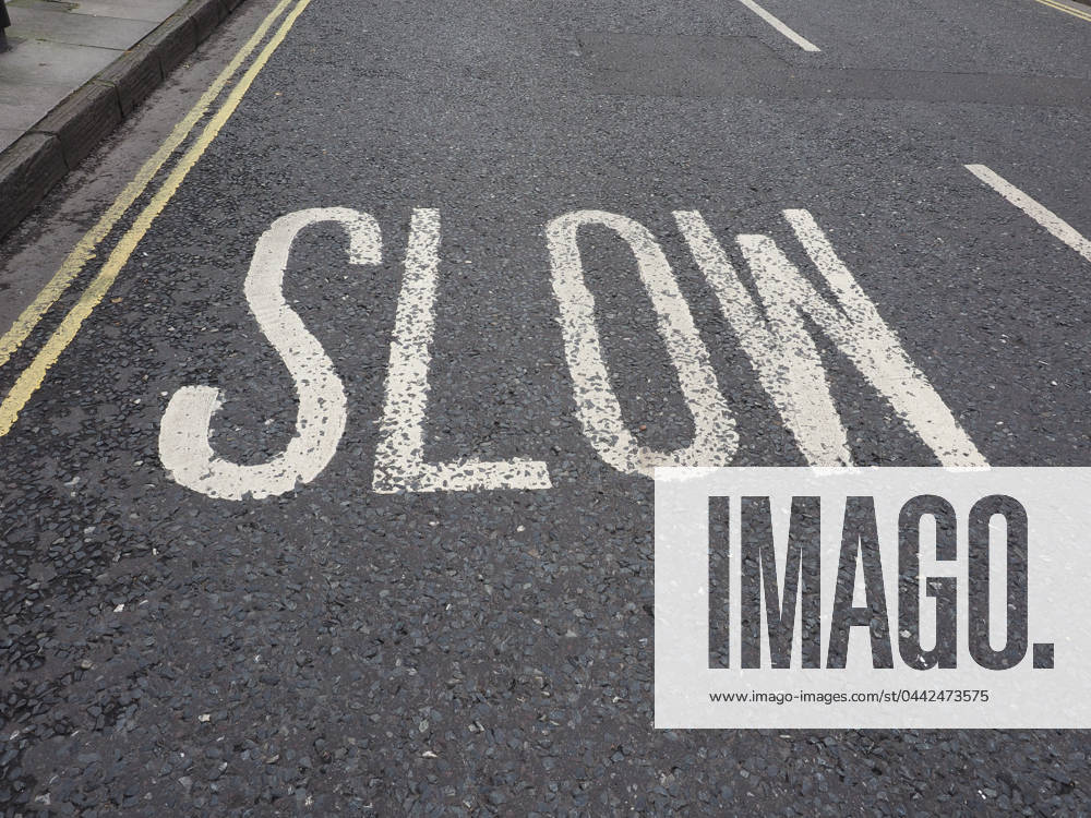 Slow Sign Post Slow street sign Slow sign written on street tarmac in