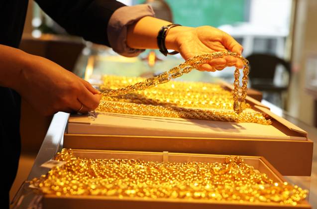 HUZHOU, CHINA - APRIL 03: An employee arranges gold ornaments at a gold ...