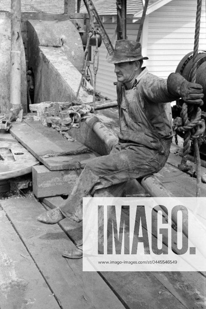 Oil field worker resting on a length of pipe, Kilgore, Texas, 1939 (b w
