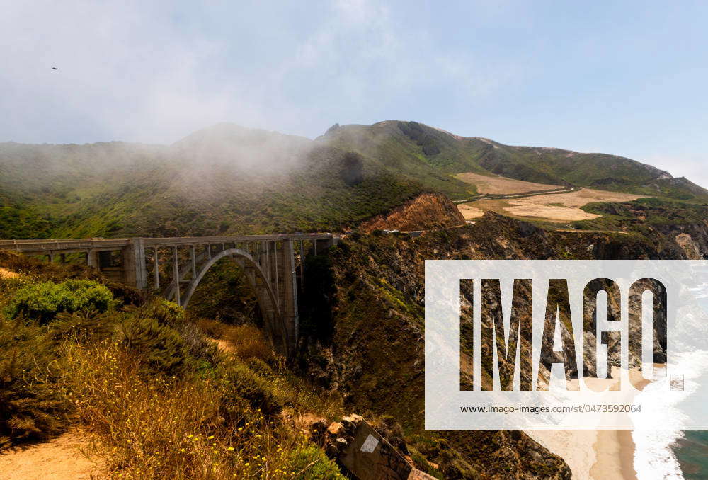 Bixby Bridge shrouded in fog along the rugged Pacific coastline ...