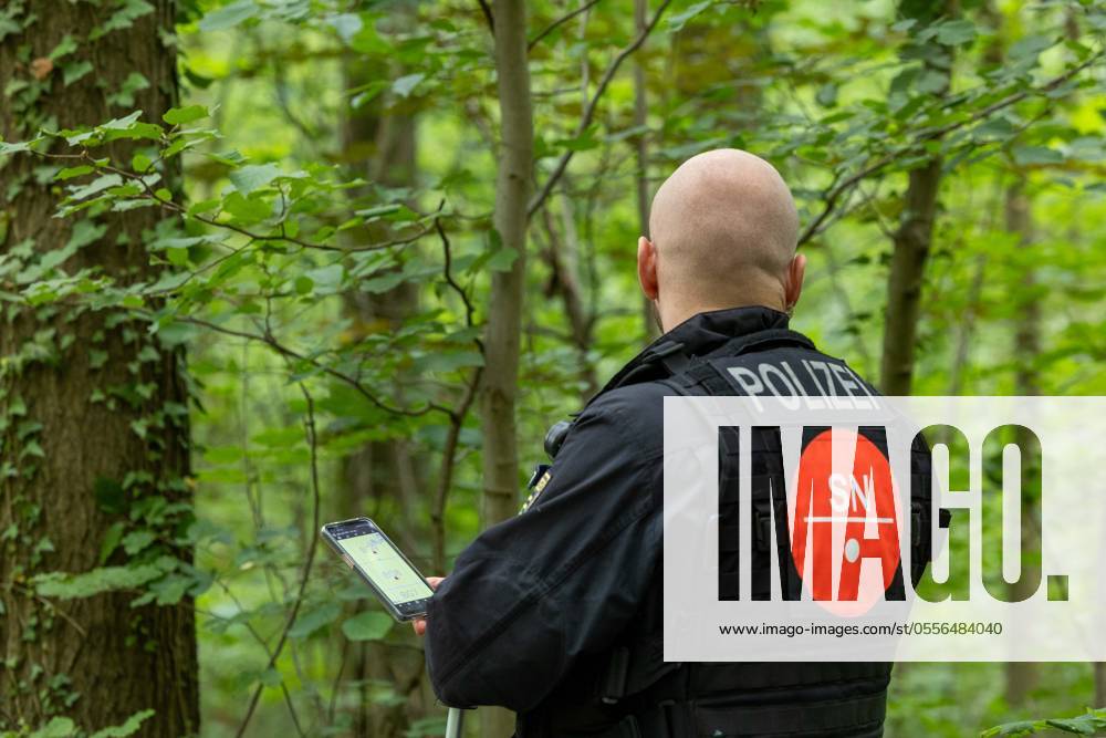 Police search woodland A police officer stands by the road holding a ...