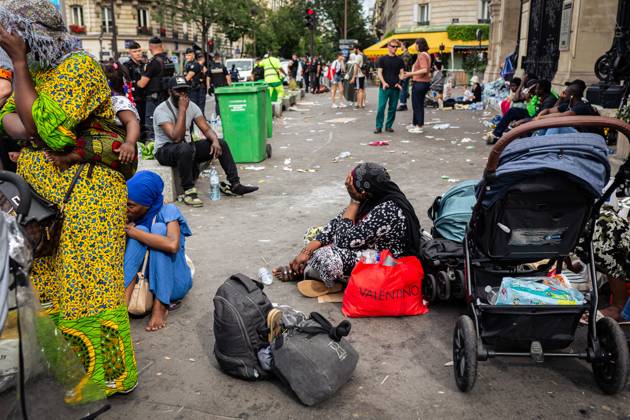 July 25, 2024, Paris, France: A homeless woman waits on the ground for ...