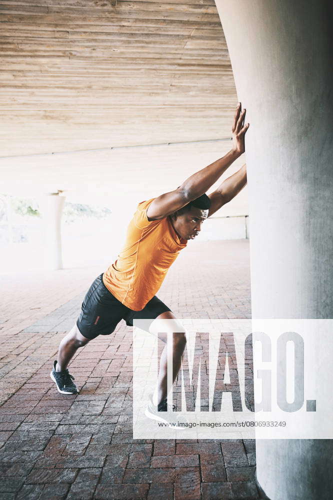 When life pushes against you, push back. a young man stretching during ...