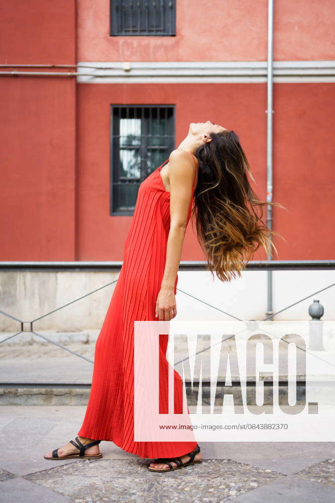 A Young Woman in a Beautiful Red Dress Posing Gracefully in a Serene ...