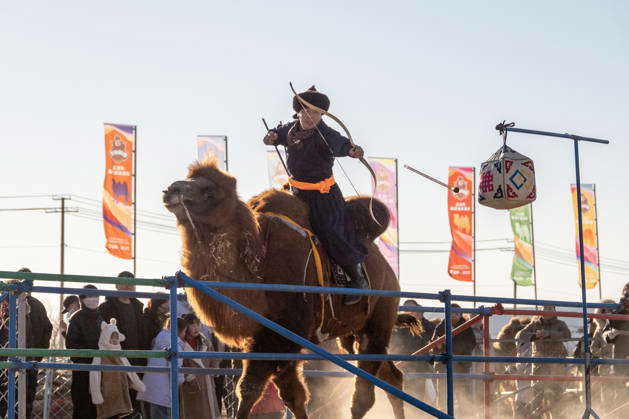 ALXA, CHINA - DECEMBER 28: A participant riding a camel performs ...